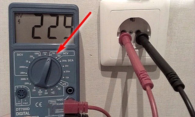 The multimeter indicates the presence of voltage